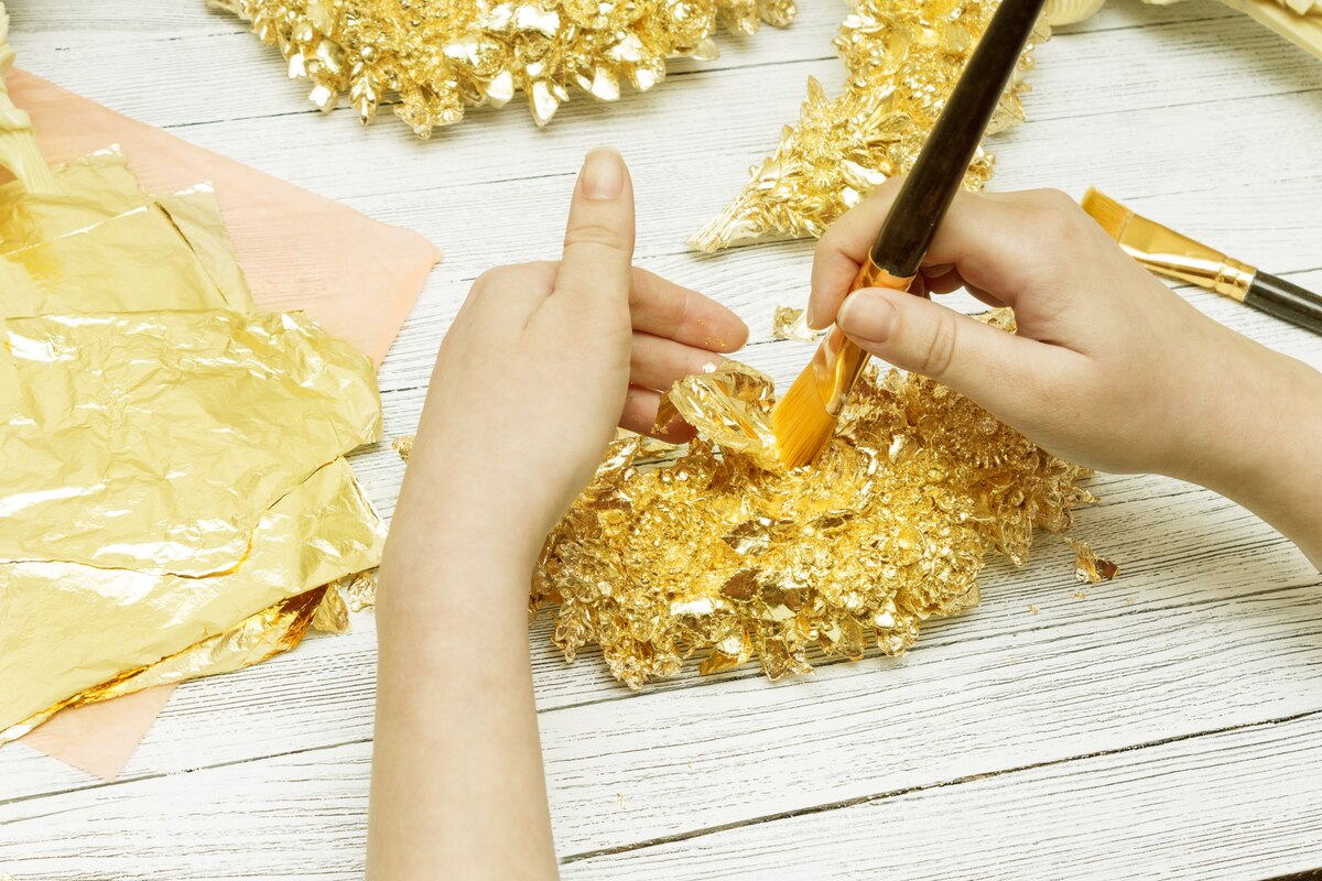 a child painting a decorated illuminated manuscript letter in gold and bright colors