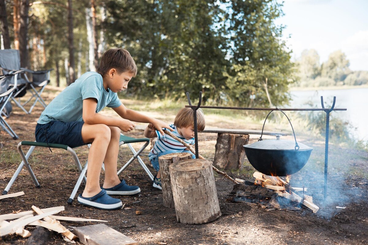 Kids cooking over a fire during a living-history enrichment class