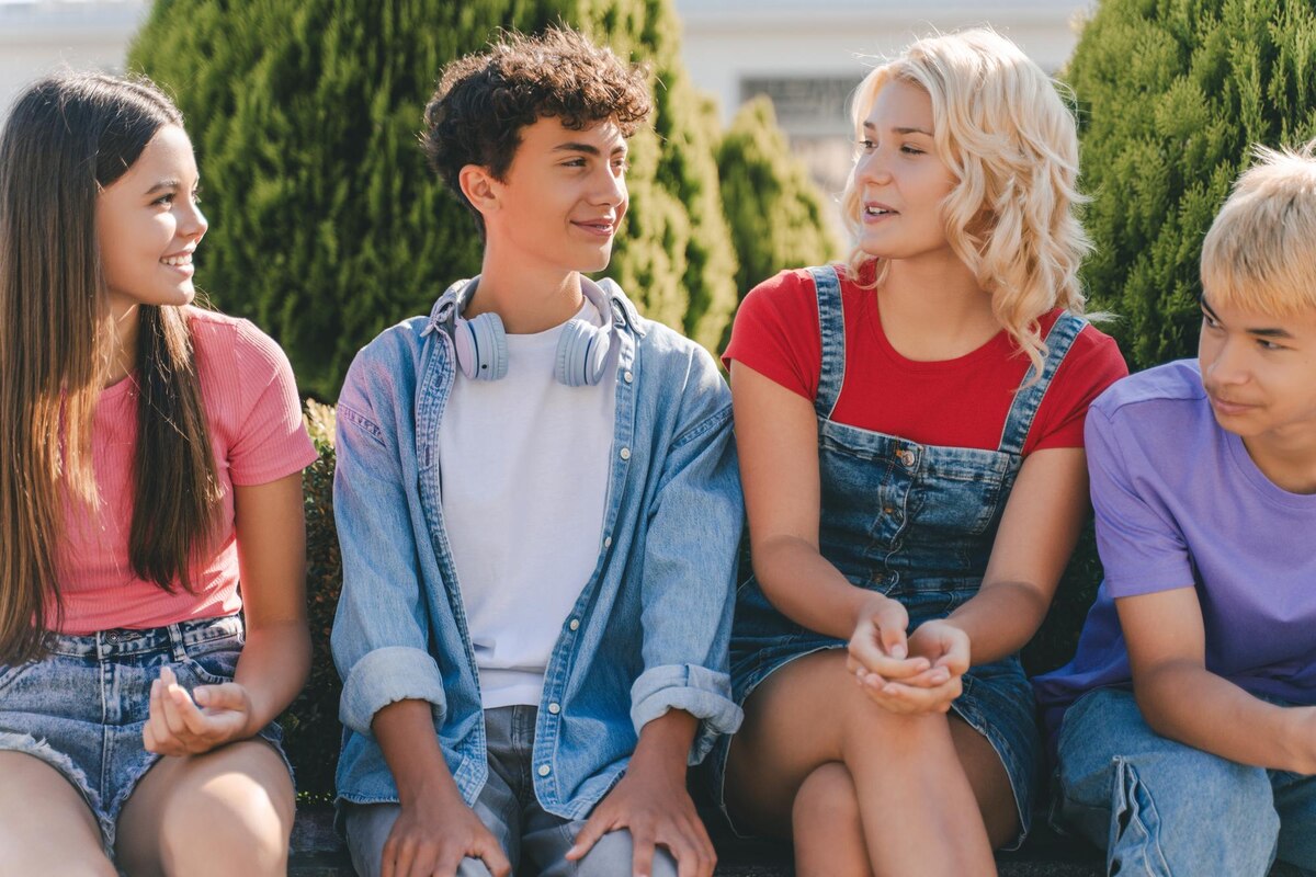 A group of homeschool teens gathered outdoors and talking during a teen meet-up