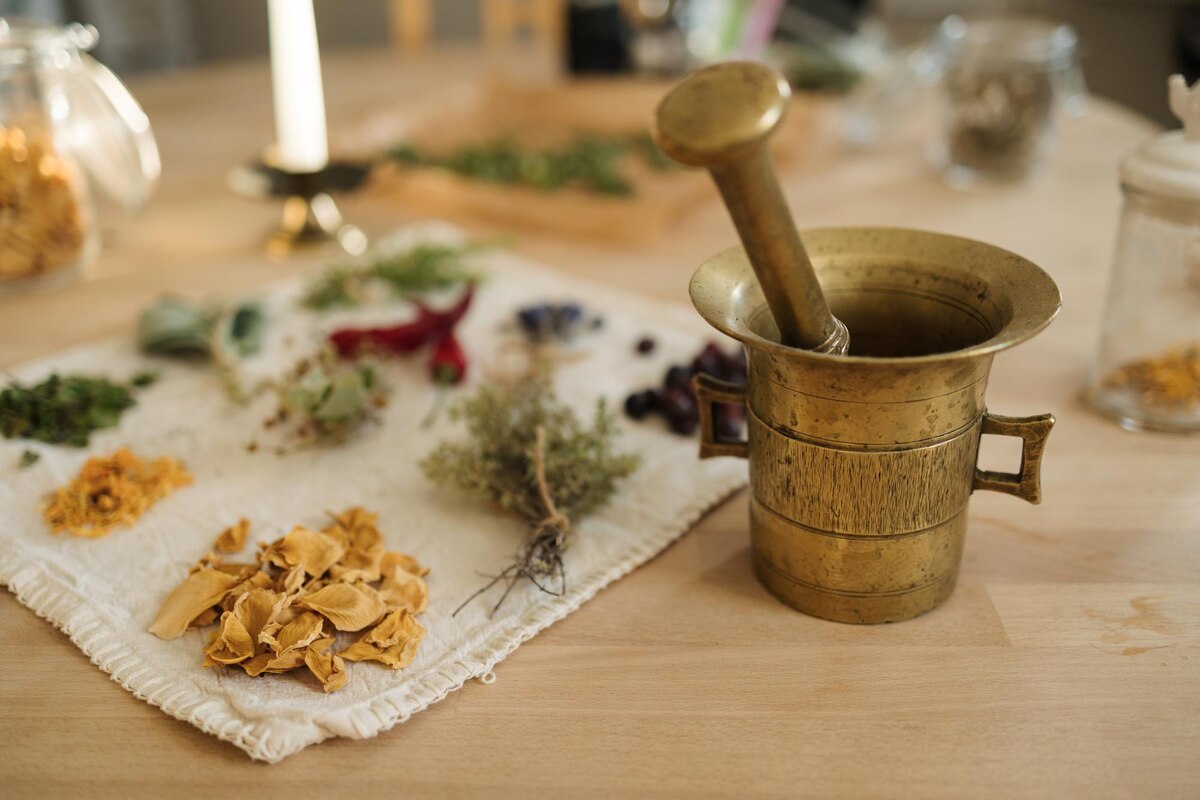 A teenager grinding herbs with a mortar and pestle during a hands-on women's history project